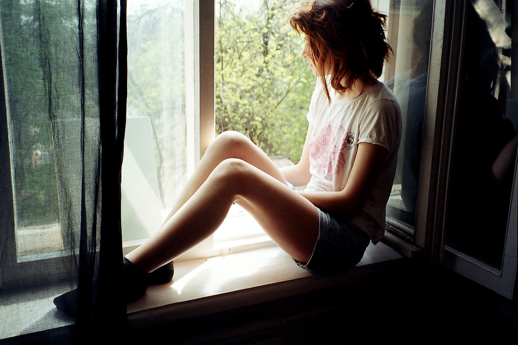 Любительские фото стройной девушки в очках возле окна