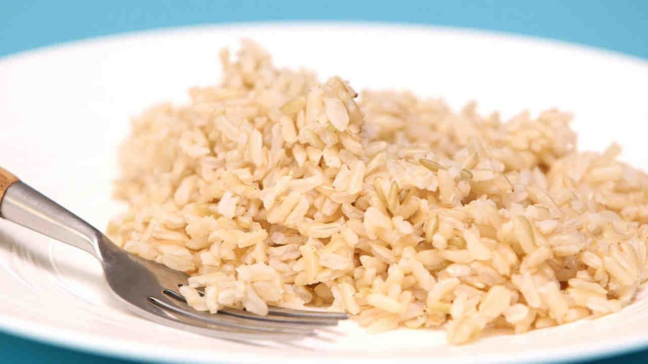 Бурый рис отварной. Бурый рис против белого риса. Неочищенный рис. Бурый рис в тарелке. Коричневый рис.