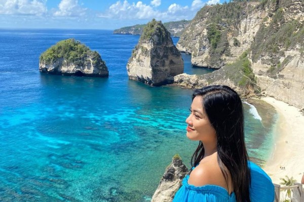 Panorama Pantai Kelingking di Nusa Penida: Tebing berbentuk unik yang menghadap ke laut biru jernih, menawarkan pemandangan alam yang menakjubkan dan spot foto yang ikonik