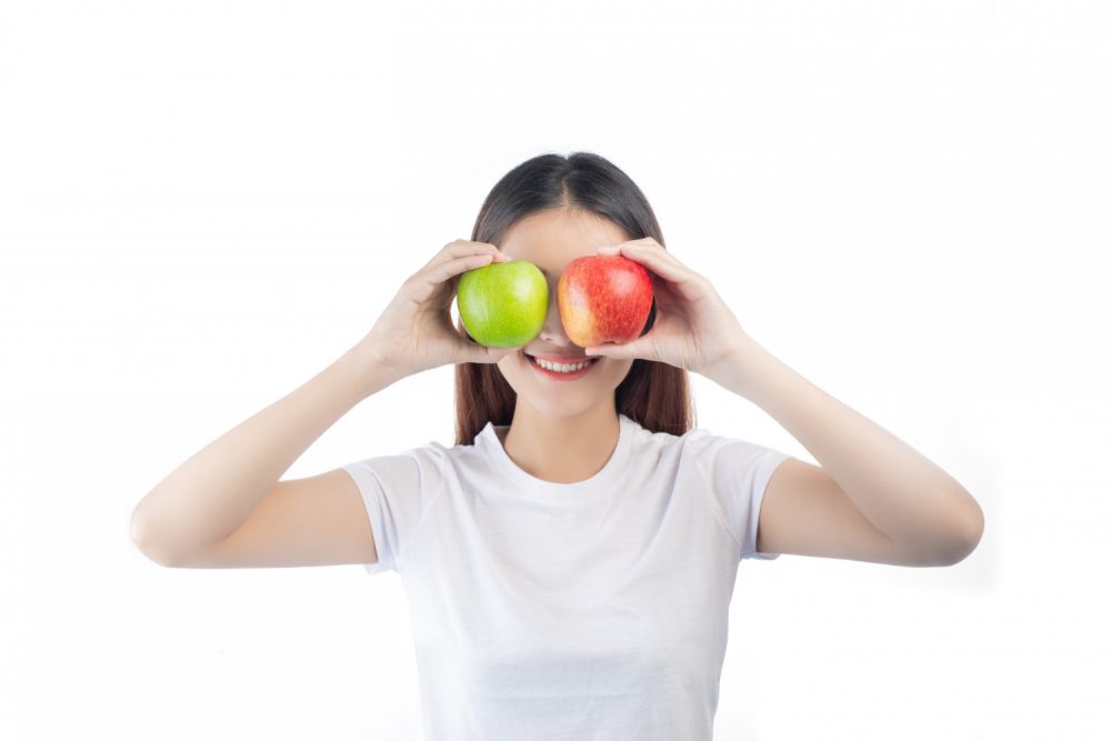 She s eating an apple. Девушка с яблоком. Девушка с яблоками картинки. Девушка с яблоком без фона. Девушка с красивой улыбкой с яблоком.