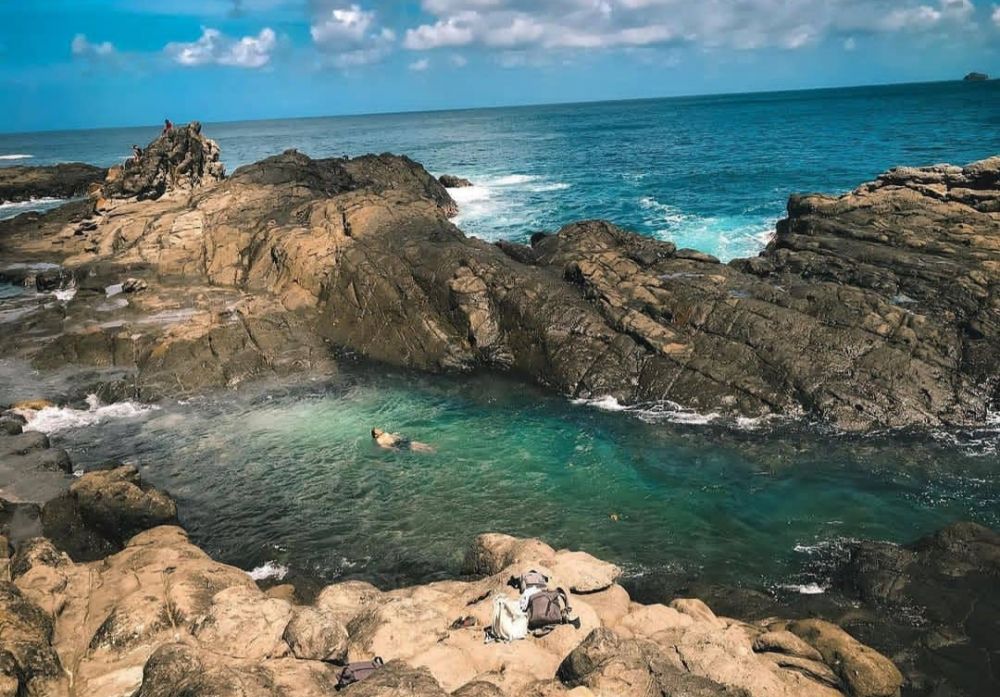 Pemandangan indah Pantai Wedi Ombo dengan pasir putih yang luas dan formasi batu karang yang unik