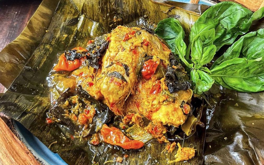 Pepes Ayam Tradisional: Ayam yang dibalut bumbu rempah khas, dibungkus daun pisang dan dikukus hingga matang sempurna, menciptakan aroma yang harum dan rasa autentik