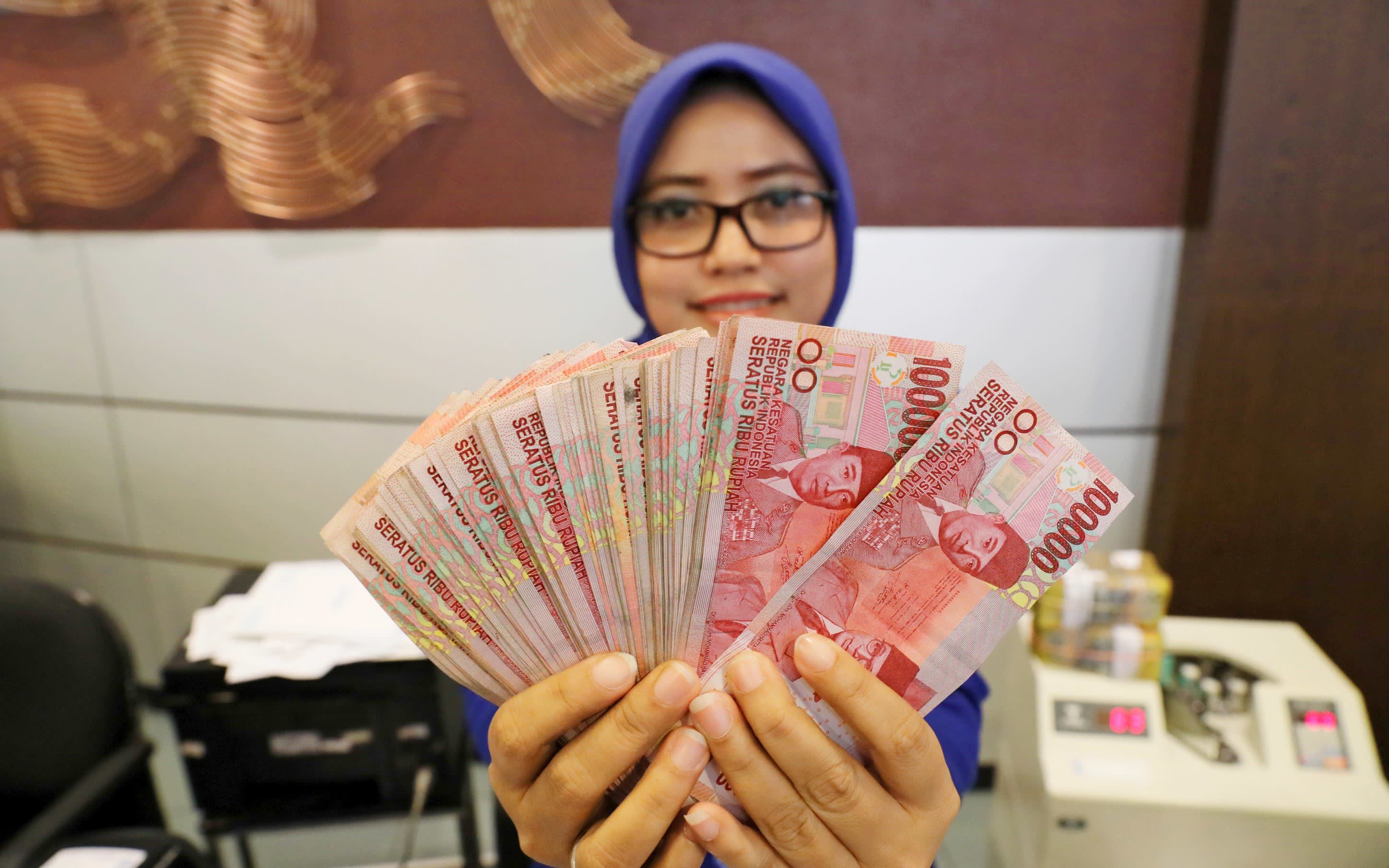 250 000 в рублях на сегодня. Девушка с деньгами. Деньги Индонезии. Индонезийка с деньгами. Индонезийские деньги в руках.
