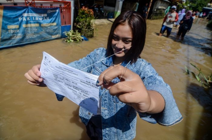 Jalan Terendam Banjir, Masyarakat Naik Perahu ke TPS untuk Nyoblos