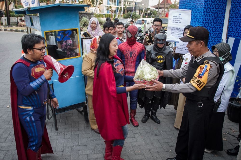 Aksi Superman, Batman, dan Spiderman Bagi-bagi Ketupat untuk Polisi