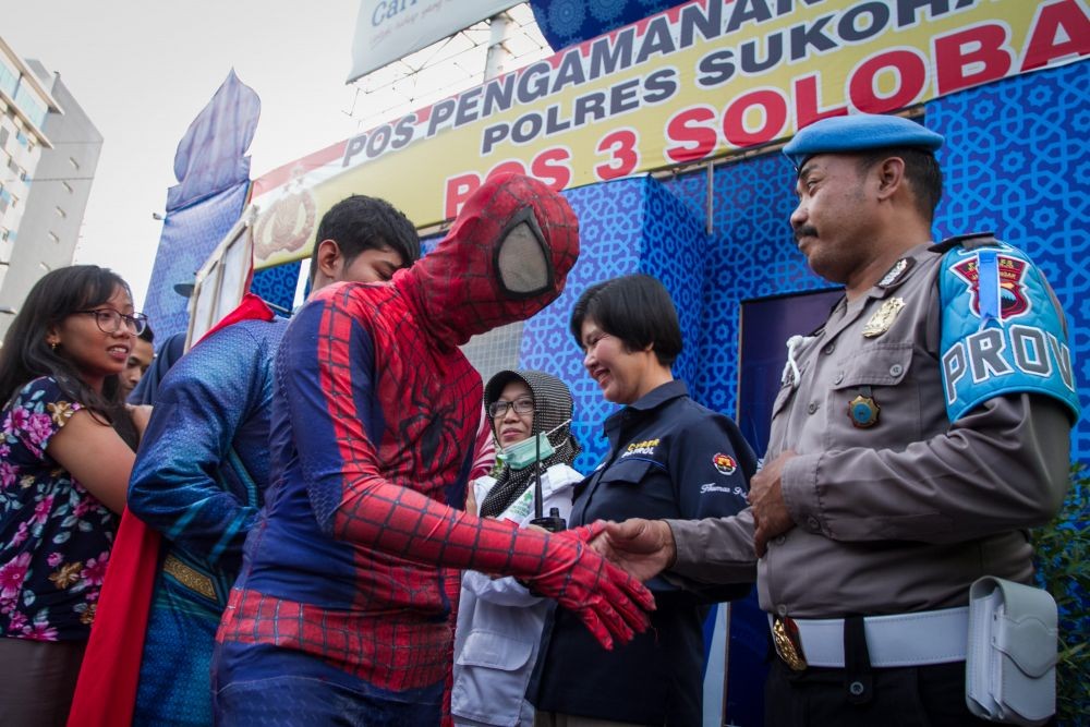 Aksi Superman, Batman, dan Spiderman Bagi-bagi Ketupat untuk Polisi
