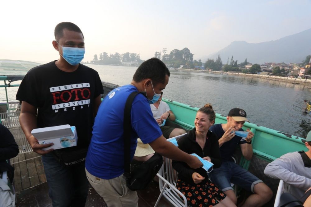 Antisipasi Kabut Asap, PFI Medan & XL Bagi Masker Gratis di Danau Toba