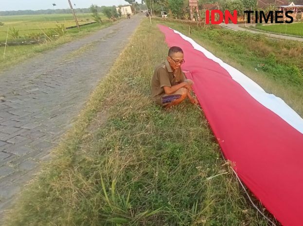 Patungan, Warga Lamongan Bentangkan Bendera 100 Meter di Bengawan Solo