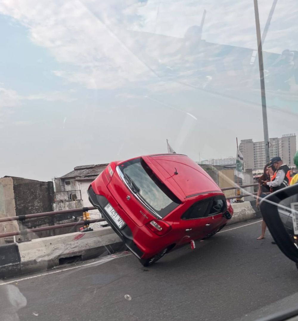 Hampir Jatuh, Baleno Merah 'Nyangkut' di Fly Over Ciputat